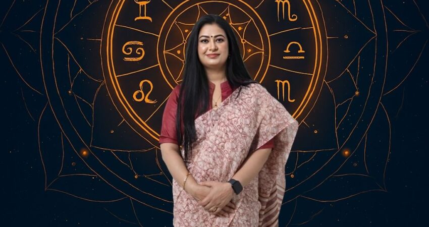 Astromadhupriya, a female Indian astrologer, stands in front of a rotating zodiac wheel and celestial map, offering accurate life predictions and effective solutions in Raj Nagar Extension, Ghaziabad. Contact details for consultation are visible.